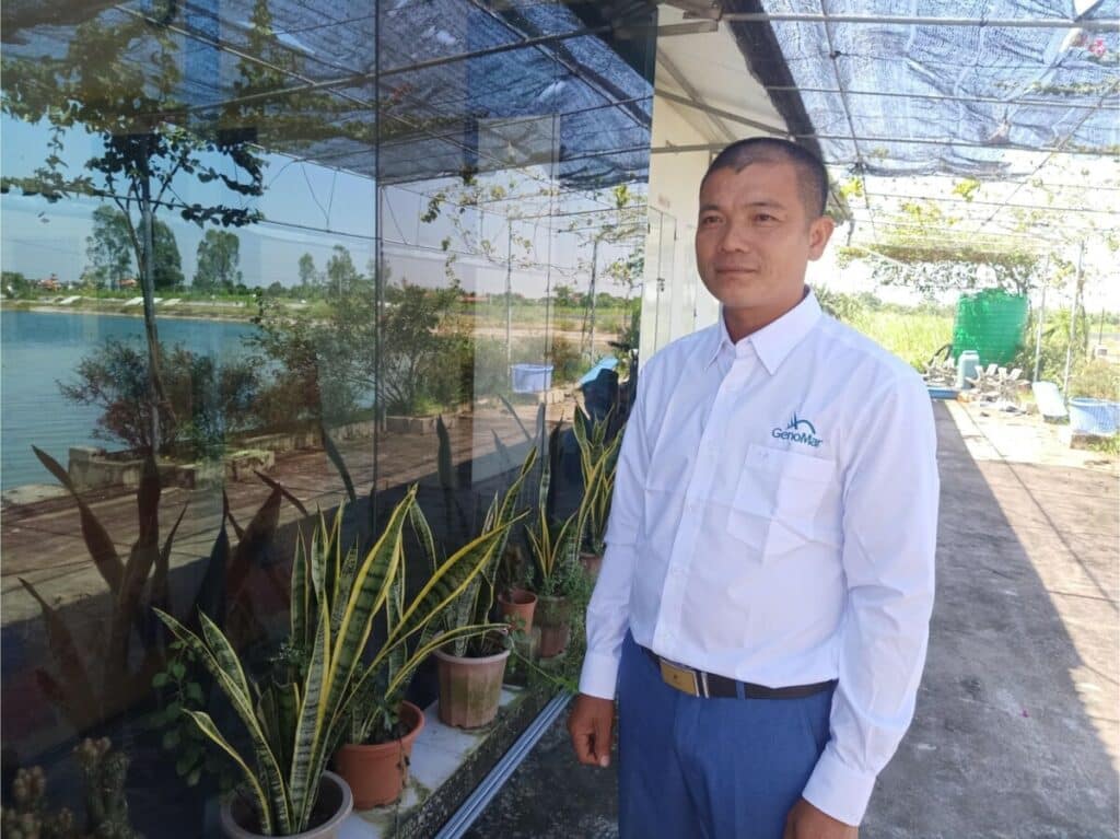 Vietnamese tilapia farmer standing beside his farm.